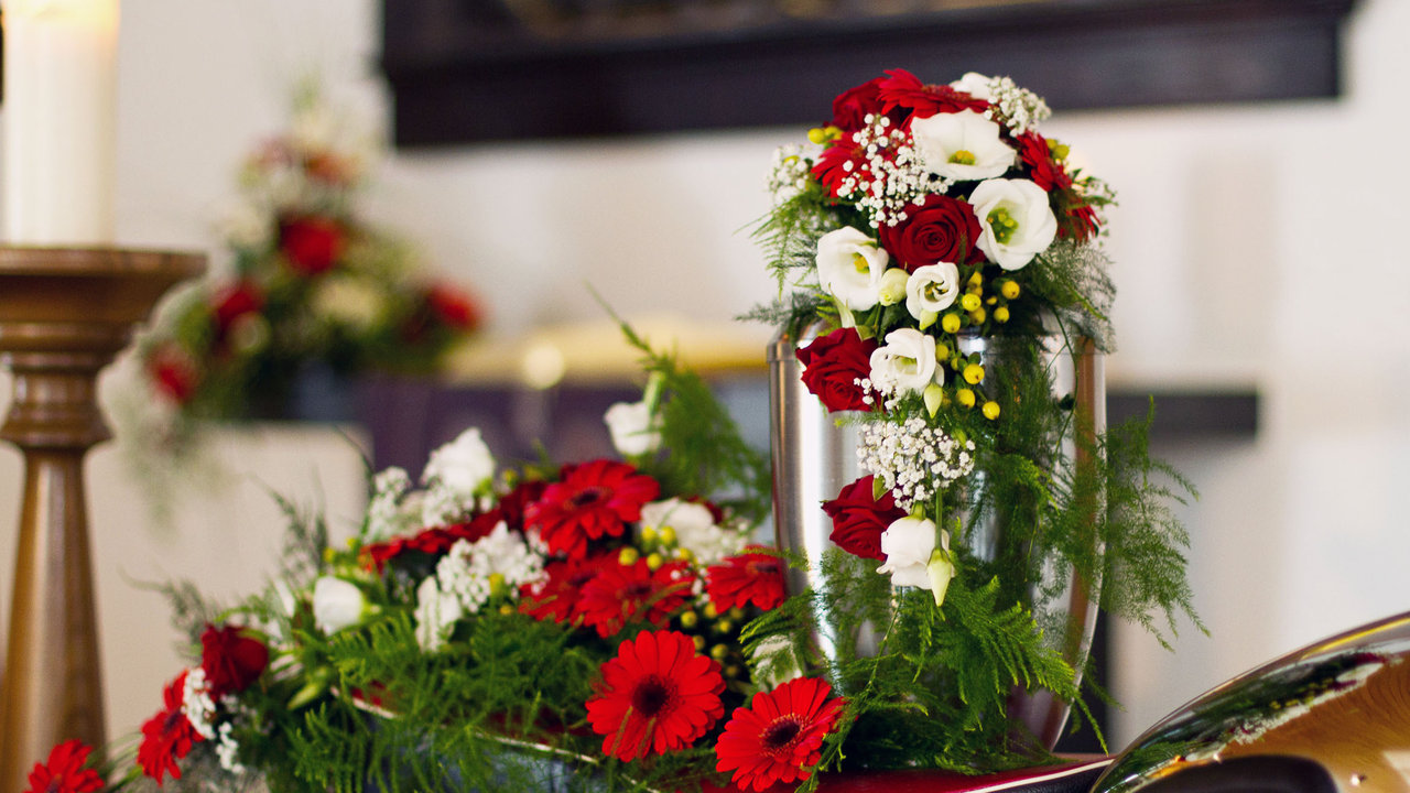 Blumen umarmen die Urne und symbolisieren die Liebe der Familie